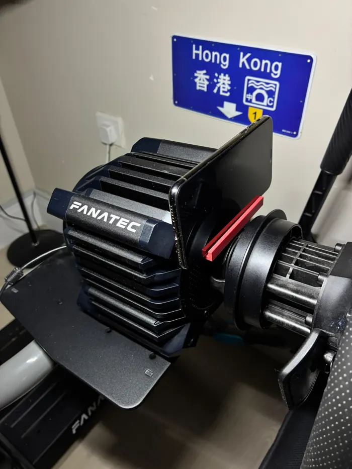 Red 3D printed phone rail on a sim-racing wheelbase